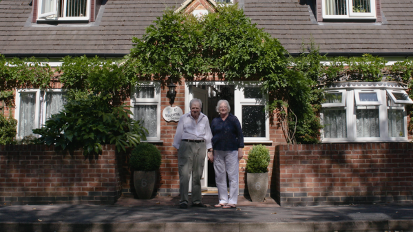 A picture of David Watson and his Wife outside the front of their house together