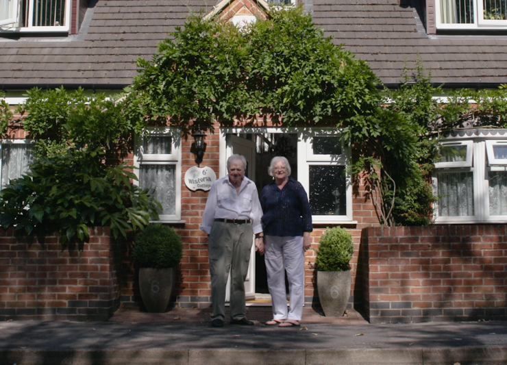 A picture of David Watson and his Wife outside the front of their house together